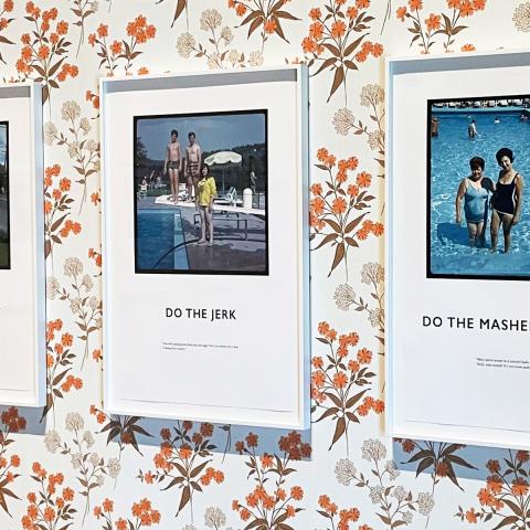 Gallery wall with orange flower wallpaper with our vacation photos hung in frames.