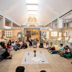 A class gathers around objects in the Visions and Values exhibition.